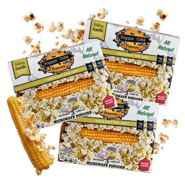 Poppin' Cobs popcorn packages with popcorn kernels and a corn cob on a white background