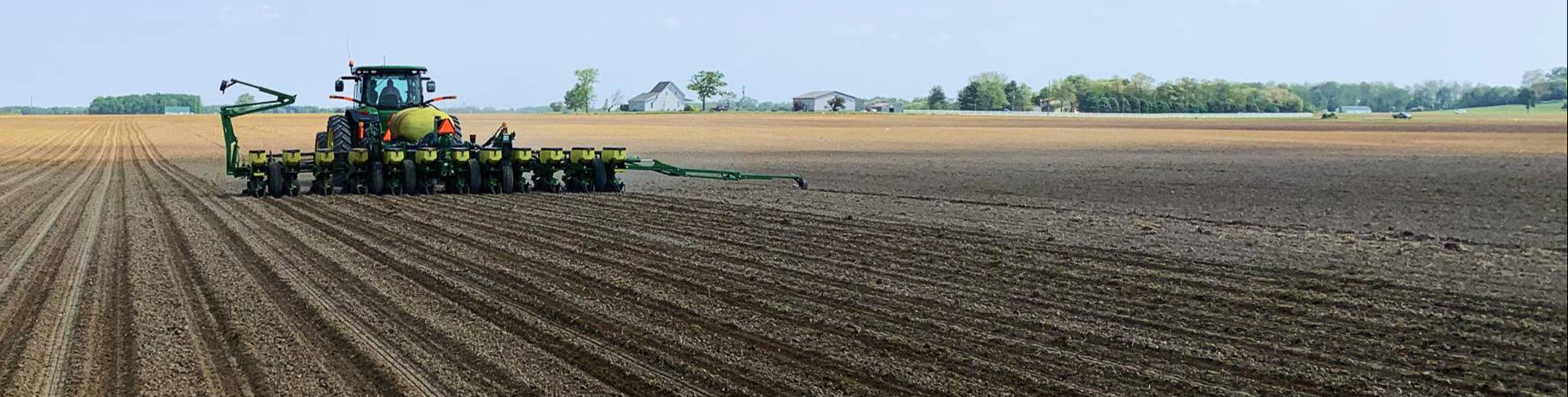 Tractor plowing a field with a clear blue sky