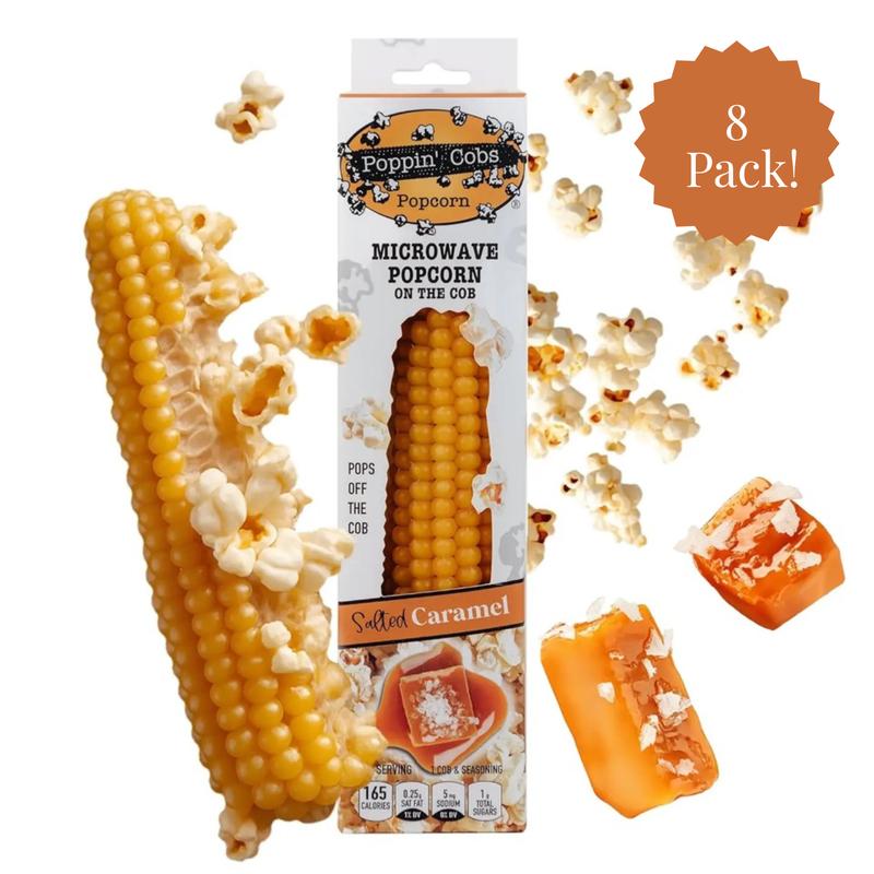 Poppin' Cobs Popcorn on a cob with packaging and caramel pieces on a white background